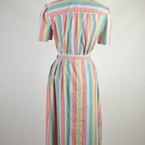 May include: A long, striped dress with a pink, yellow, blue, and green color scheme. The dress has a short sleeve and a belt.