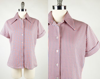 May include: A short-sleeved button-up shirt with a white background and a geometric pattern in red and blue.