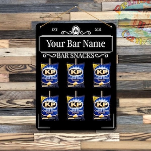 May include: Black chalkboard sign with the text "EST 2022 Your Bar Name BAR SNACKS" and six images of bags of KP Original Salted Peanuts.