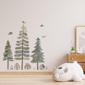 Può includere: Un adesivo murale raffigurante una scena di foresta con alberi in stile acquerello, piccole case e uccelli. Gli alberi sono in varie tonalità di verde e le case sono marroni. Un peluche bianco a forma di orso è sul pavimento.