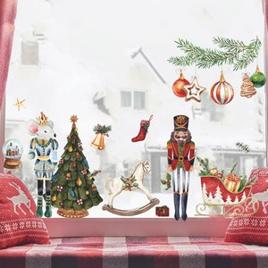 May include: Watercolor Christmas window decals featuring a festive scene. Includes a nutcracker, Christmas tree, ornaments, a rocking horse, and a sleigh. The scene is set against a snowy backdrop, with red and green accents.
