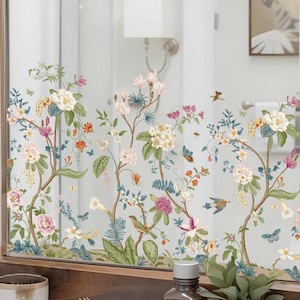 Peut inclure: Un miroir décoratif avec un motif floral comprenant des fleurs roses, blanches et jaunes, des feuilles vertes et des papillons. Le miroir est encadré dans un cadre en bois et se trouve au-dessus d'une étagère en bois.