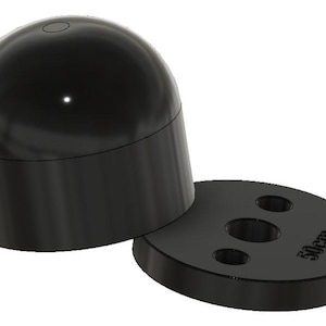 May include: A black, smooth, dome-shaped object sits next to a flat, circular black base. The base features three circular holes and the text 50cm embossed on its surface. Both components have a matte finish and a simple, geometric design.