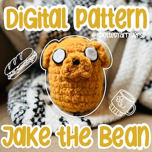 Puede incluir: Un juguete de peluche tejido a crochet de Jake el Perro de la serie animada Adventure Time. Jake es de color marrón amarillento y tiene la nariz y los ojos blancos. El texto "Digital pattern" y "@knottedyarnuniverse" están en la parte superior de la imagen. El texto "Jake the Bean" está en la parte inferior de la imagen.