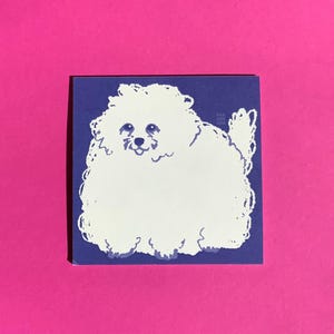 Pode incluir: Um autocolante quadrado com uma ilustração branca de um cão fofo sobre um fundo azul. O cão tem uma expressão sorridente. O autocolante está sobre um fundo rosa.