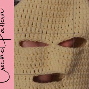 May include: A close-up of a crocheted face mask with eye and mouth holes. The mask is made with a beige yarn and has a textured stitch pattern.