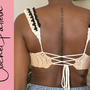 May include: A crochet top with a white and black striped trim and a tie back. The top is made with a beige yarn.