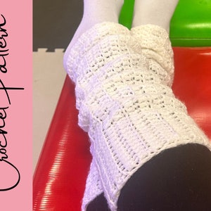 May include: White crochet leg warmers with a textured pattern are shown. The text "Crochet Pattern" is on the left side of the image. The leg warmers are worn over black leggings and white socks.