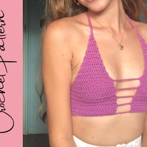 Puede incluir: Un top halter de crochet morado con un dise&ntilde;o cruzado en la parte delantera.