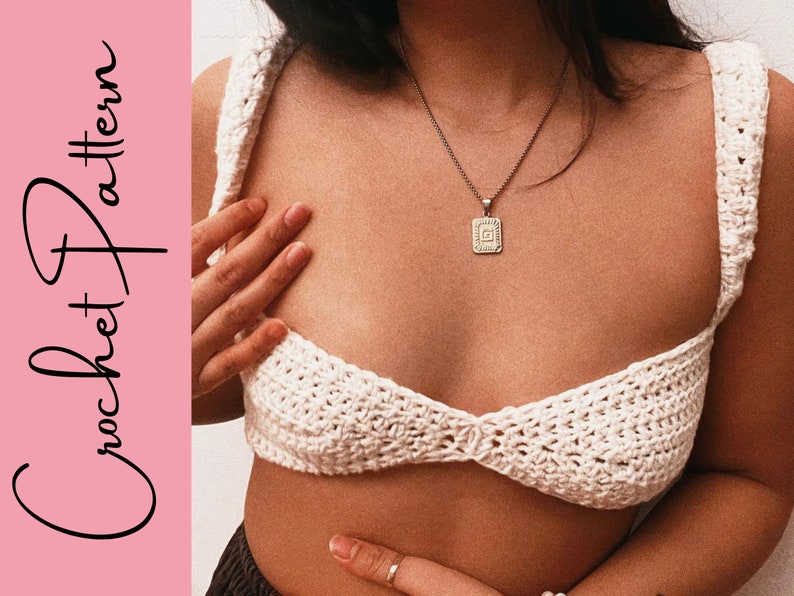 May include: White crochet crop top with a delicate, intricate stitch pattern. The top has a low-cut neckline and thin straps.