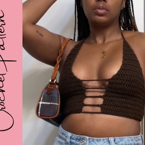 Puede incluir: Un top de halter de crochet marr&oacute;n con un dise&ntilde;o de corte. El top se lleva sobre un par de pantalones vaqueros azules.