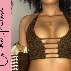 Puede incluir: Un top halter de crochet marr&oacute;n con un dise&ntilde;o de corte en la parte delantera. El top est&aacute; hecho con un punto de crochet sencillo y tiene un estilo simple y minimalista.