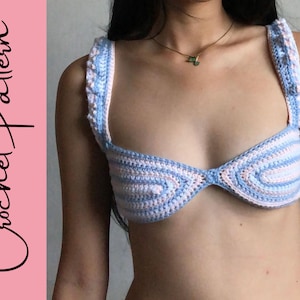 May include: A crocheted bikini top with a blue and pink striped pattern. The top has a sweetheart neckline and adjustable straps.
