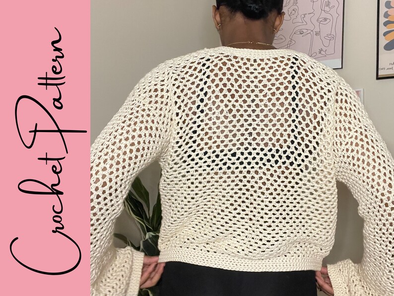May include: A white crochet top with a loose fit and a large open stitch pattern. The top has long sleeves and a cropped length.