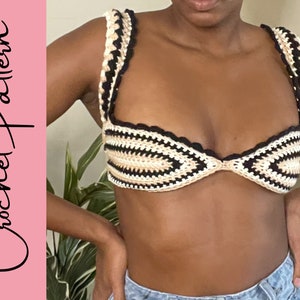 May include: A crocheted bikini top with black, white and beige stripes. The top has a scalloped edge and a tie closure at the back.