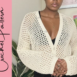 May include: A white crochet cardigan with a button-up front and long sleeves. The cardigan has a loose, open-weave design.