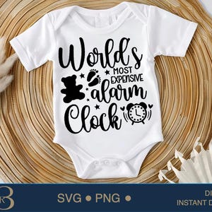 May include: White baby onesie with black text that reads "World's Most Expensive Alarm Clock". The text is surrounded by a teddy bear, stars, and a clock.