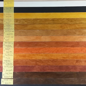 May include: A wood stain color chart with 16 different wood stains. The stains are labeled with their names and the corresponding wood type. The stains range in color from natural to black.
