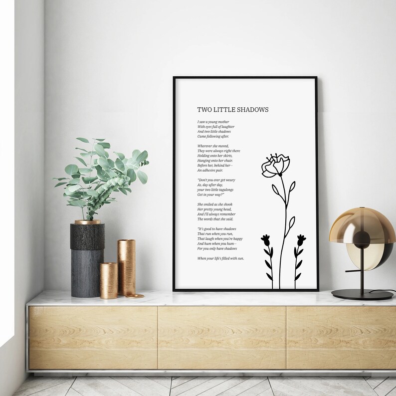May include: Black and white printable wall art featuring a poem titled "Two Little Shadows" with a simple line drawing of two flowers. The poem reads: "I saw a young mother with two little shadows..."