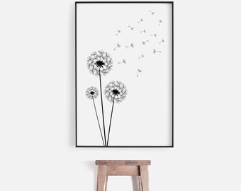 May include: Black and white line art print of three dandelions with seeds blowing in the wind. The print is framed in a black frame and is hanging on a white wall.