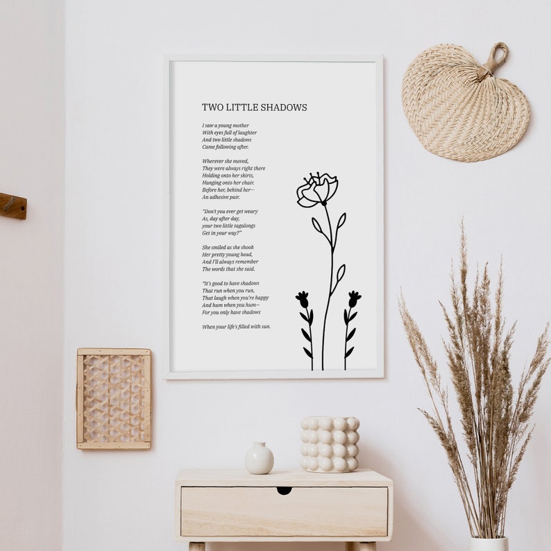 May include: A black and white printable wall art print with a poem titled "Two Little Shadows" about a young mother and her two children. The poem is surrounded by a simple black floral illustration.