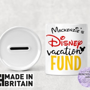 May include: White ceramic piggy bank with a slot on top. The front of the bank has a yellow, red, and black design that says "Mackenzie's Disney vacation FUND".
