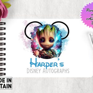 May include: A white A6 autograph book with a spiral binding. The cover features a colorful illustration of a character from the Guardians of the Galaxy movie, Groot, with a blue and purple galaxy background. The text "Harper's Disney Autographs" is printed in blue below the illustration.