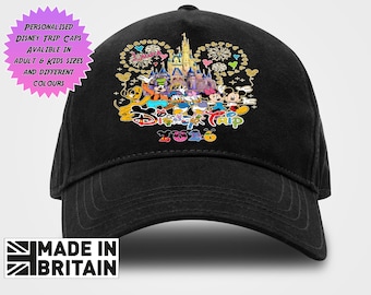 May include: A black baseball cap featuring a colorful graphic of Disney characters including Mickey Mouse, Minnie Mouse, Donald Duck, and Goofy in front of a castle with fireworks. The text reads Disney Trip 2026 in a stylized, multi-colored font.