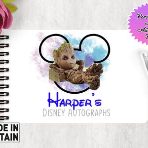 May include: A white A6 autograph book with a blue and purple watercolor Mickey Mouse design. The design features a character from the Guardians of the Galaxy movie, Groot, sitting in the ear of Mickey Mouse. The book has the text "Harper's Disney Autographs" printed on the front.