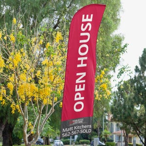 May include: A tall, red feather flag featuring the white text OPEN HOUSE in a vertical orientation. The bottom section is black with a gray box for a logo, the name Matt Kitchens, and the phone number 562-567-SOLD printed in white text.