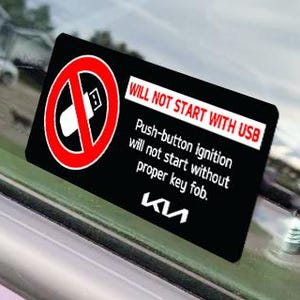 May include: A black and white decal with red accents for a Kia car. The decal reads "WILL NOT START WITH USB Push-button ignition will not start without proper key fob. KIA".