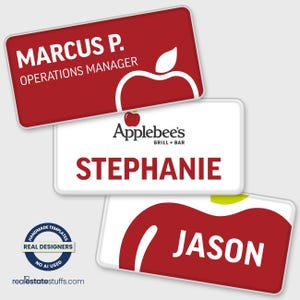 May include: Three rectangular name badges with rounded corners. One is red with white text reading MARCUS P. OPERATIONS MANAGER and an apple graphic. One is white with the Applebee's logo and STEPHANIE in red. One is white with a red apple and JASON.