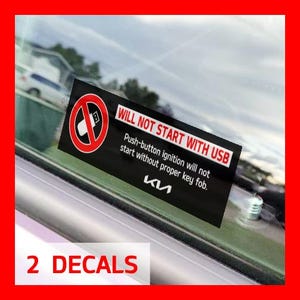 May include: Two black and white decals with the text "WILL NOT START WITH USB" and a red circle with a diagonal line through a USB icon. The text below the circle reads "Push-button ignition will not start without proper key fob." The text "KIA" is below the text.