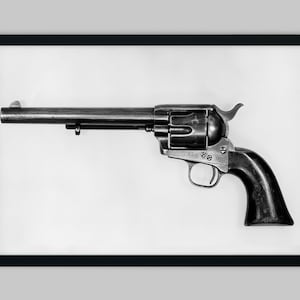 May include: A black and silver revolver with a wooden handle. The gun is in a black frame.