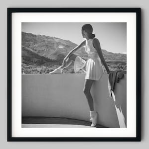 Fashion model wearing tennis outfit, seated on wall looking at the mountains Black and White Photography Fine Art Print - Wall Decor