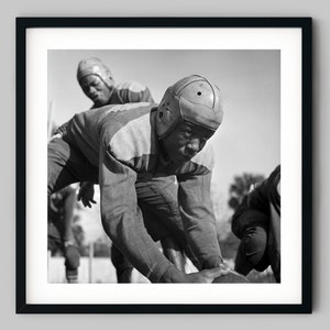 African American man with a helmet snaps the football to his quarterback during a game Black and White Photography Fine Art Print Wall Decor