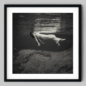 Woman floating on the water of a lake with a dress on - Black and White photograph fine art print wall decor
