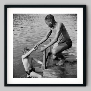 Boy helps another child on to a dock from the summer lake Black and White Photography Fine Art Print - Wall Decor