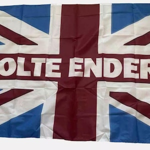 Può includere: Una bandiera bianca con una croce rossa e triangoli blu, con il testo "HOLTE ENDERS" in lettere bianche.