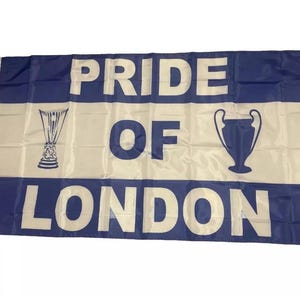 May include: A flag with a white central panel and blue borders. The words "PRIDE OF LONDON" are printed in large white letters. Two blue trophy illustrations are also present on the flag.