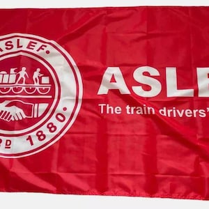 Puede incluir: Una bandera roja con un círculo blanco que contiene el texto "ASLEF. ESTABLISHED 1880." y un gráfico de un tren y dos figuras dándose la mano. El texto "ASLEF The train drivers' union" está impreso en blanco sobre fondo rojo.