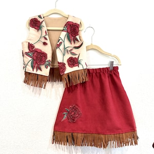 Red Rose cowgirl pageant outfit. Tan vest with rose mesh overlay, matching dark red skirt with rose appliqué. Tan fringe.