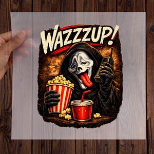 Pu&ograve; includere: Un trasferimento grafico con una figura incappucciata con maschera bianca, lunga lingua rossa e veste nera. La figura tiene in mano un cellulare vintage, un secchiello per popcorn a righe rosse e bianche e un bicchiere rosso. Testo WAZZZUP! in alto.