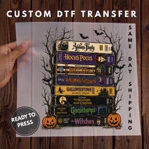 Puede incluir: Una hoja de transferencia DTF transparente que muestra una pila de siete cintas VHS antiguas con t&iacute;tulos de pel&iacute;culas de Halloween, incluyendo The Addams Family, Hocus Pocus, Beetlejuice, Halloweentown, The Nightmare Before Christmas, Goosebumps y The Witches.