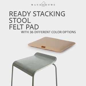 May include: A light gray stool with a matching felt pad in a neutral beige color. The text on the image reads "READY STACKING STOOL FELT PAD WITH 36 DIFFERENT COLOR OPTIONS". The stool has a minimalist design.