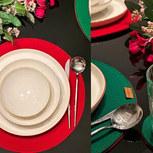May include: A round red felt placemat featuring a stacked white dinner plate, salad plate, and bowl, accompanied by a silver fork, knife, and spoon. A second green felt placemat holds a silver spoon, knife, and a clear textured glass tumbler.