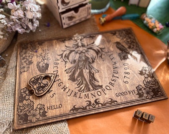 May include: A wooden Ouija board with a planchette, a witch figure, and the alphabet, numbers, and words "hello", "goodbye", and "yes".