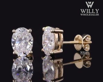 May include: A pair of gold stud earrings with round, clear cubic zirconia stones.