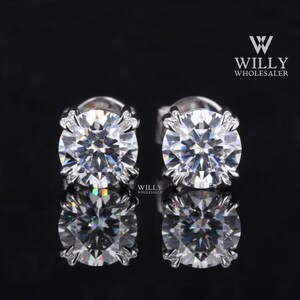 May include: A pair of silver stud earrings with large, round, clear cubic zirconia stones. The stones have a faceted design and sparkle.