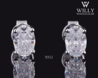 May include: A pair of silver stud earrings with oval-shaped clear cubic zirconia stones.